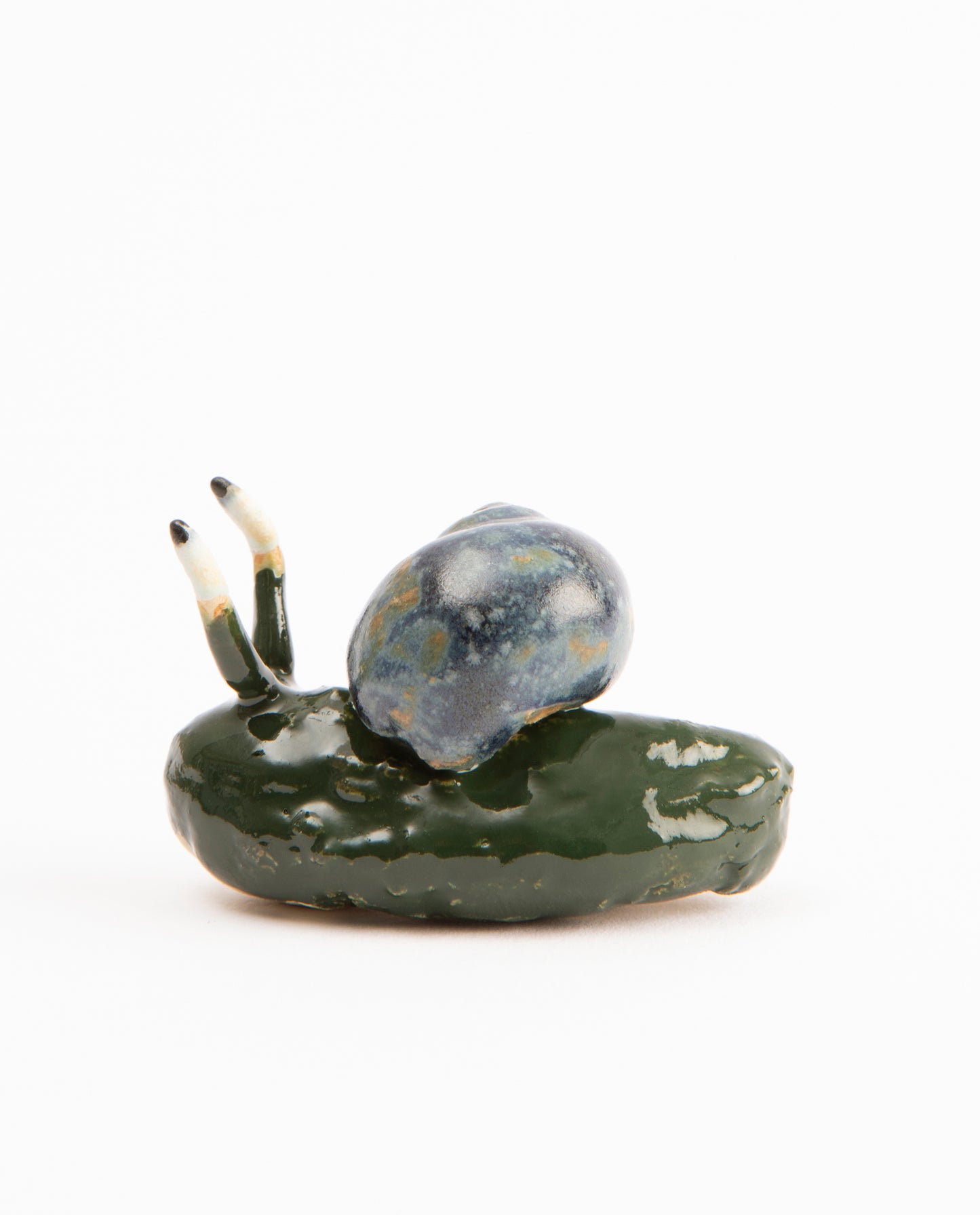 Escargot en céramique, dont le corps est un cornichons. La coquille est bleue.
