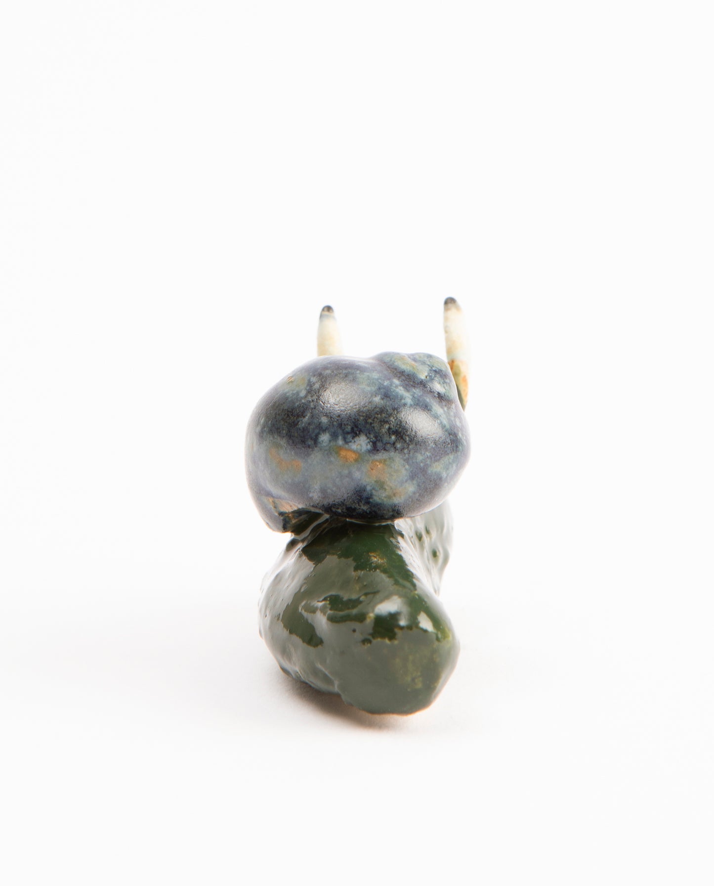 Escargot en céramique, dont le corps est un cornichons. La coquille est bleue.